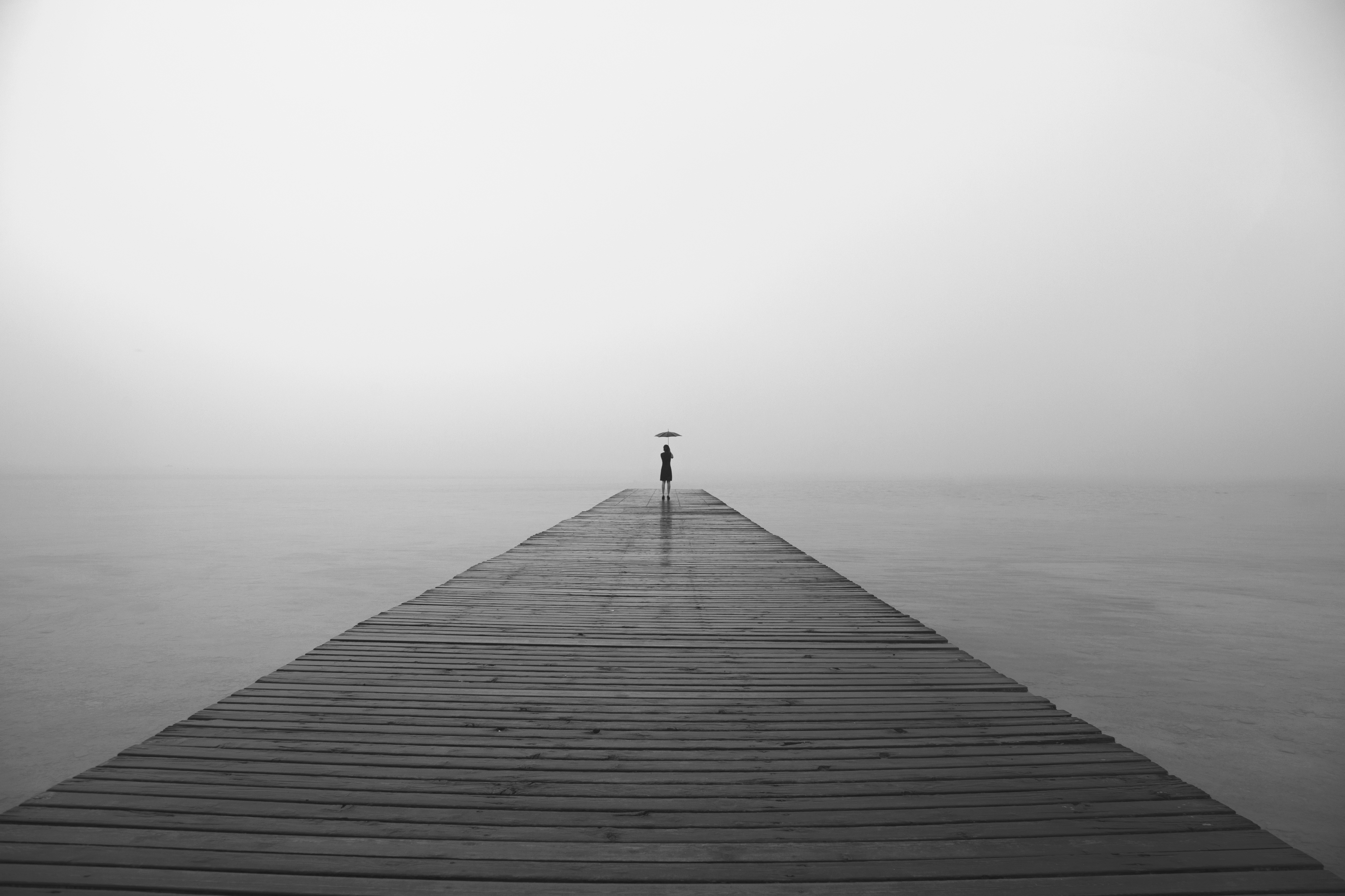 isolated woman with a black umbrella a depressing gray day