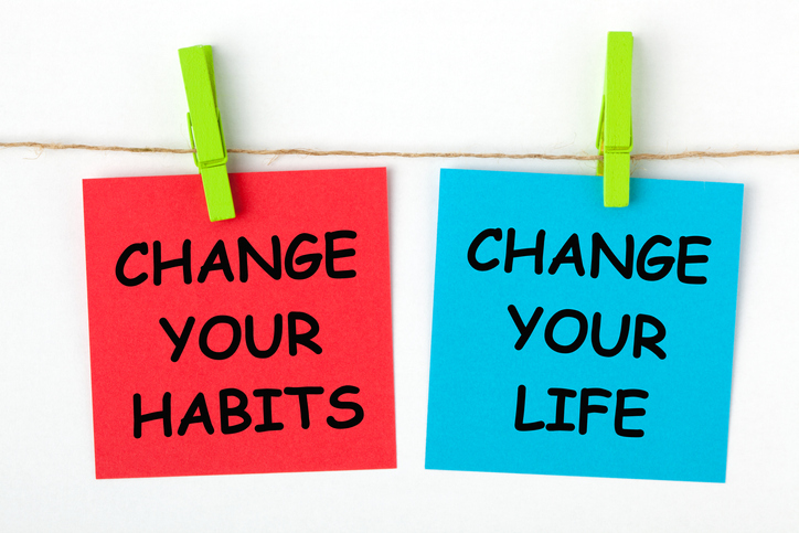 Change your habits, change your life written on color notes and hanging on clothespins